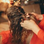 Tressage de cheveux devant un décor de fêtes